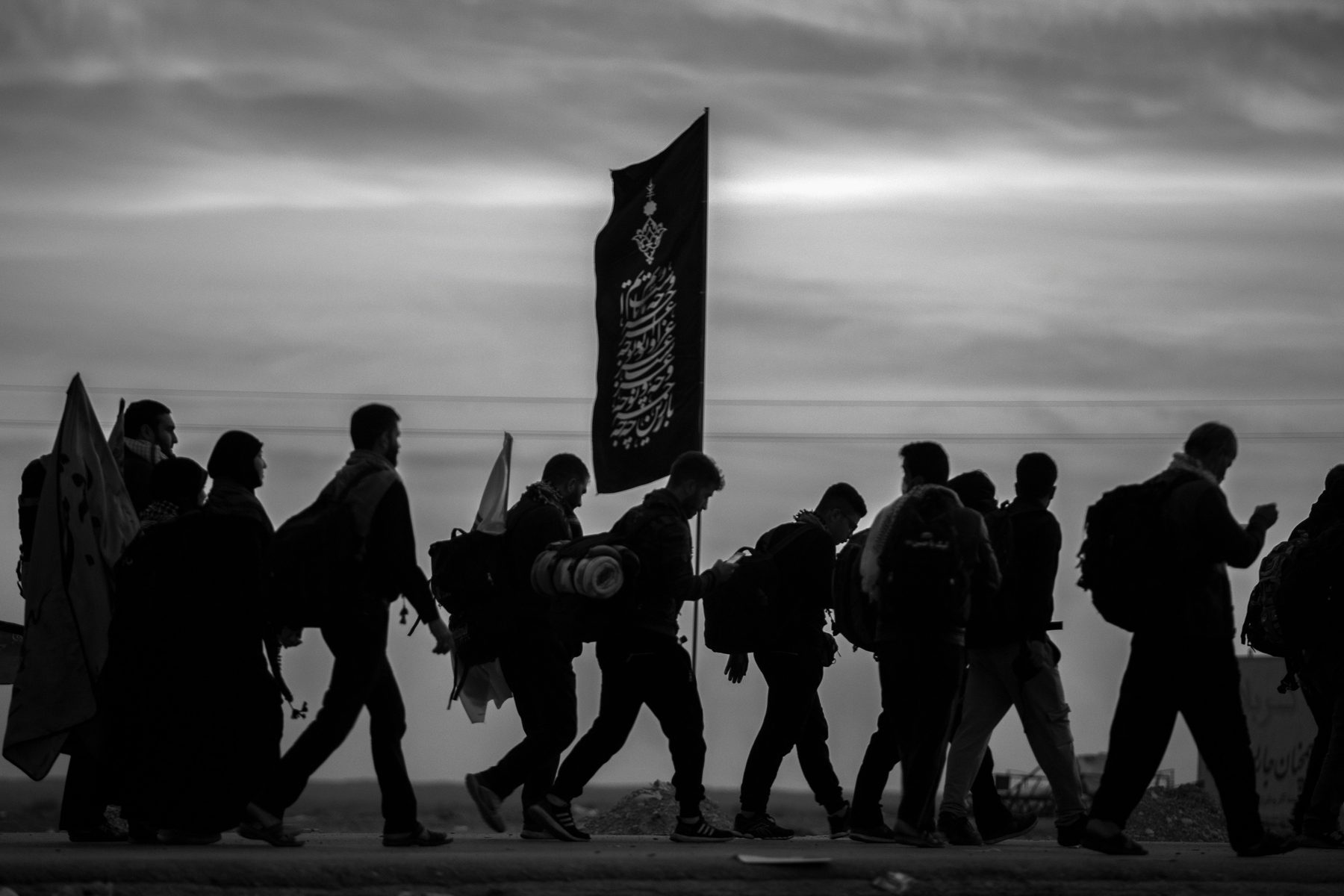 Black and white procession scene with flags